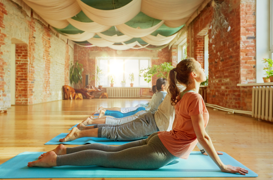 Group yoga practice of the cobra pose for releasing stored up stress and tension in the body.