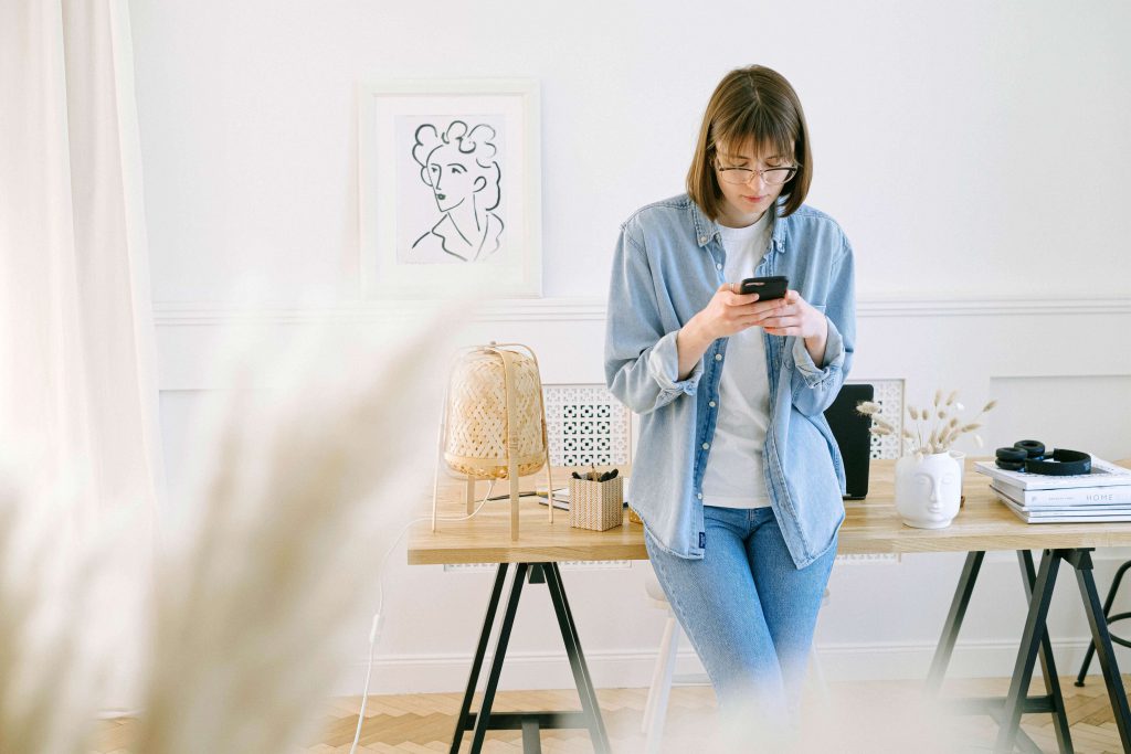 a woman standing and texting on her phone