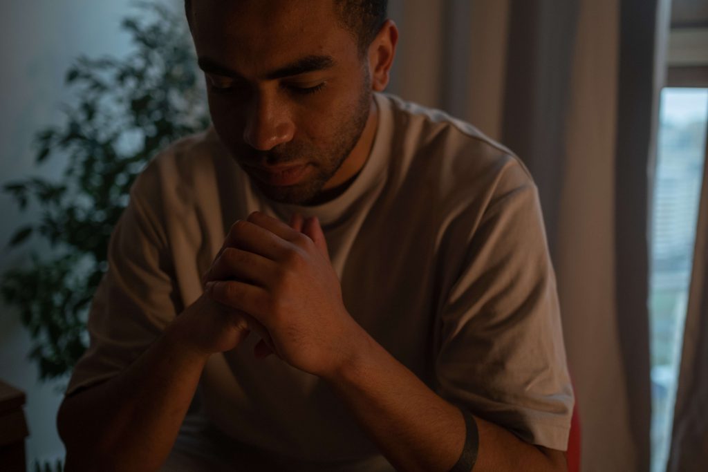 a man sitting down looking distressed