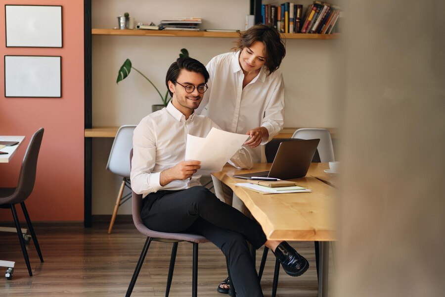 young-smiling-business-colleagues-happily-working-with-papers-modern-office